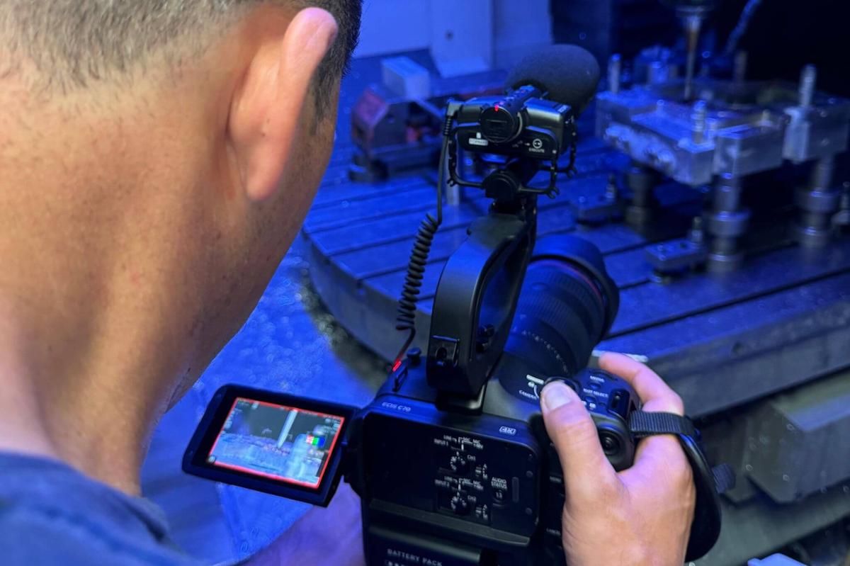 Nahaufnahme einer Kamera beim Filmen einer Maschine im Industriebetrieb