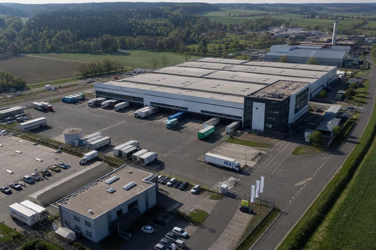 Drohnenaufnahme eines Industriegebäudes mit Außenanlagen und Logistikflächen — visuelle Bestandsaufnahme. Dieser Inhalt wurde mit Künstlicher Intelligenz erstellt.