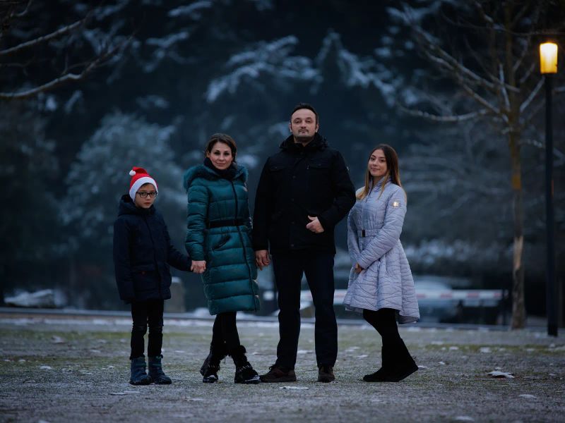 Familie zu dritt in winterlicher Kleidung — Mutter, Vater und Tochter im Freien