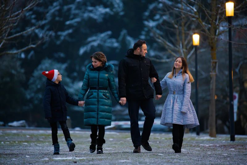 Familie spaziert durch einen winterlichen Park