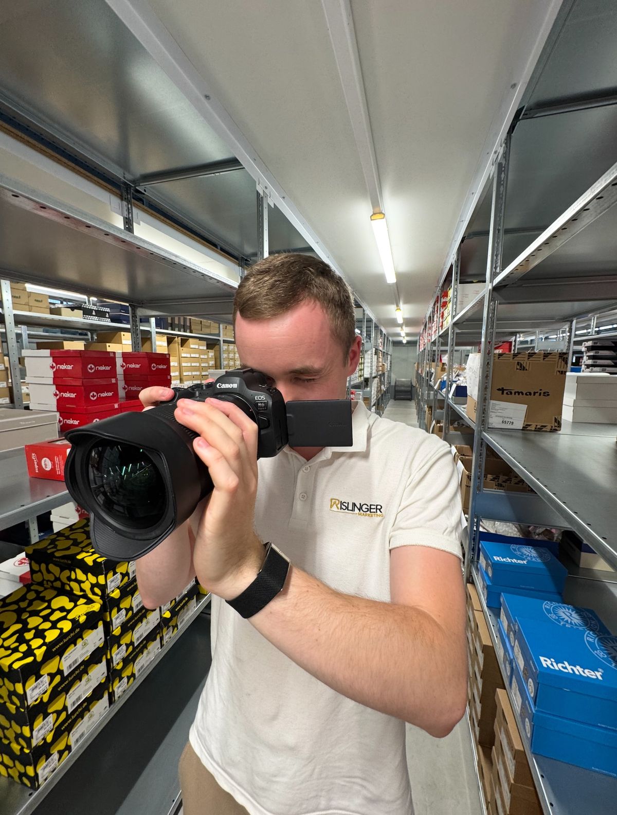 Philipp Ritz mit der Kamera bei der Foto- und Videoproduktion im Lager von Majo Markenschuhe