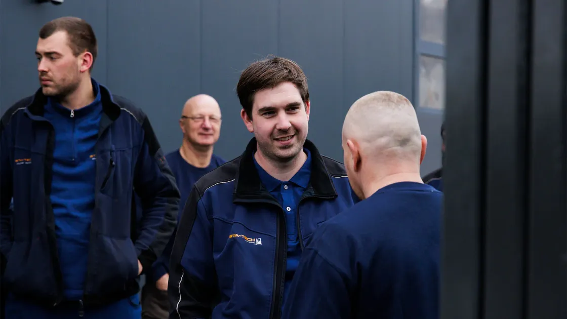 STA-TECH-Team im Gespräch vor dem Firmengebäude